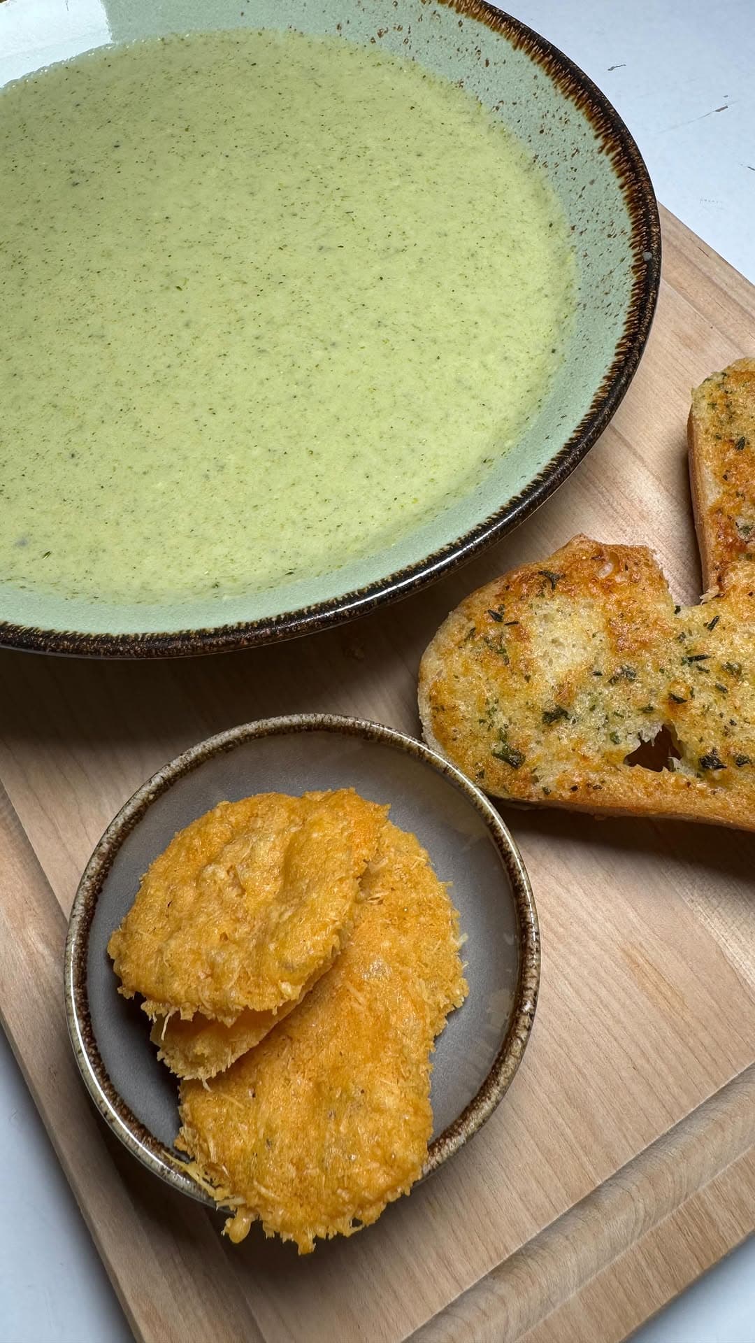 Cremiges Brokkolisüppchen mit knusprigen Parmesan-Chips und Parmesan-Baguette
